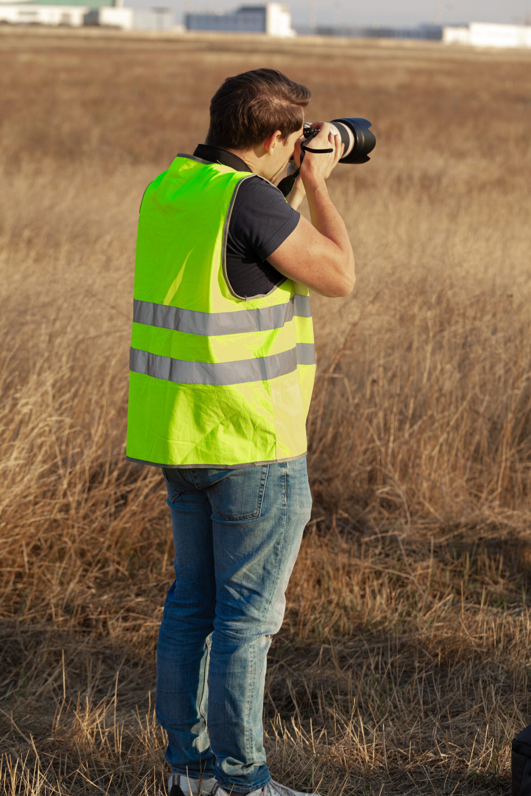 Lekker Studios - man in yellow vest does plane spotting at the airp 2023 11 27 05 06 26 utc scaled | Professional Luxury Photography